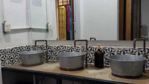 Communal bathroom next to the living room; three sinks with tiles, with a waist to roof mirror.