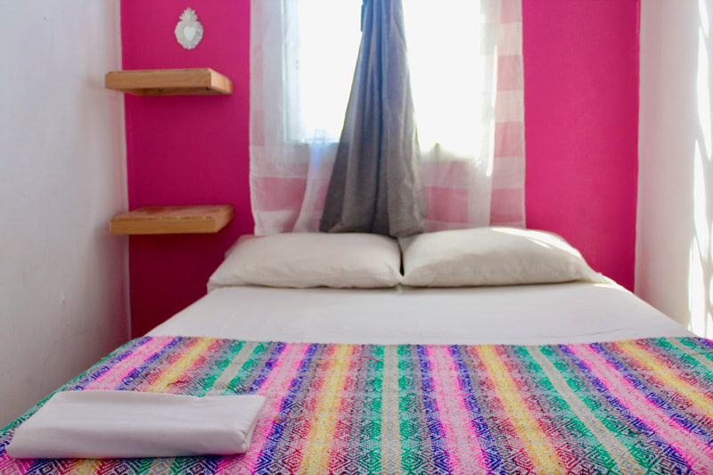 CUARTO ROSA:

Private room with a full bed, shares bathroom and showers only with another room. Recommended if you are a couple or just looking to spread out in a bed. Not recommended if privacy is not your priority. Can fit up to 2 people.