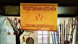 Vegetarian kitchen in the hostel; a guest cooking in the vegetarian kitchen.